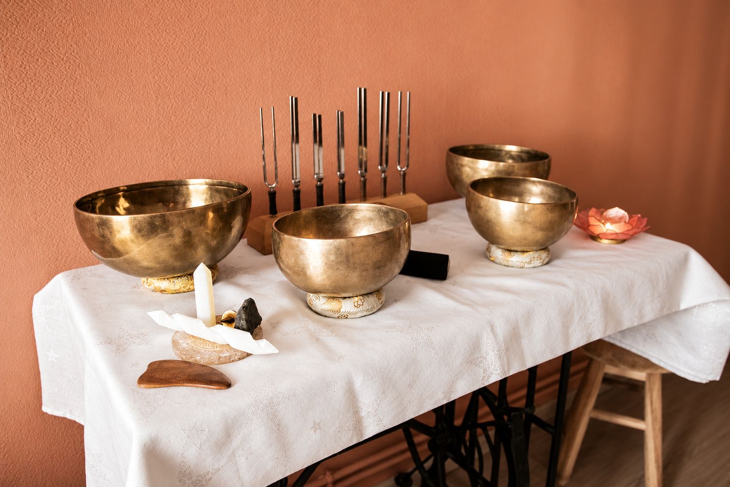 Bols tibétains et diapasons disposés sur une table ancienne, matériel de sonothérapie d'Émilie Stephanus